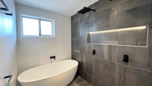 a bathroom with a large white tub and a window at Beachside Bliss In The Crown in Kawana Waters +5 photos
