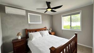 a bedroom with a bed with a ceiling fan at Beachside Bliss In The Crown in Kawana Waters
