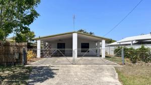 a house with a gate in front of it at Beachside Bliss In The Crown in Kawana Waters