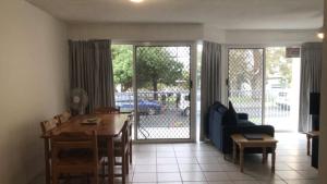 a living room with a table and a blue couch at Windbourne Unit 8 in Golden Beach