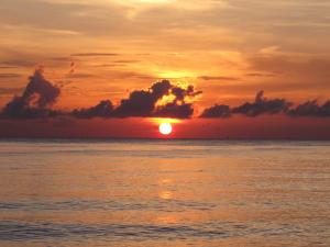um pôr-do-sol sobre o oceano com o pôr-do-sol em Matahari Tulamben Resort, Dive & SPA em Tulamben