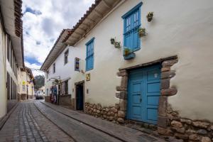 a cobblestone street in an old town with blue doors at SAN BLAS PLAZA INn in Cusco