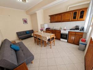 a living room with a table and a couch and a kitchen at Psarras apartments in Ipsos +3 photos