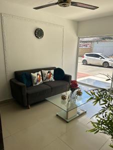 a living room with a couch and a clock on the wall at Laurel plaza 46 in Montería