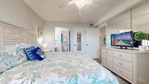 a bedroom with a large bed and a flat screen tv at Summit 1013 in Panama City Beach
