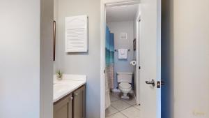 a bathroom with a white sink and a toilet at Summit 1013 in Panama City Beach