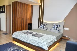 a bedroom with a large bed with blue and white pillows at UnigoOne Apartments, BH, Palolem in Canacona