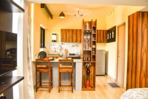 a kitchen with wooden cabinets and a counter top at UnigoOne Apartments, BH, Palolem in Canacona