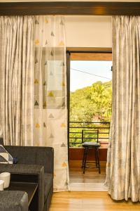 a living room with a couch and a window at UnigoOne Apartments, BH, Palolem in Canacona