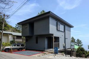 a gray house with a black roof at KomoreNest伊豆熱川 in Higashiizu