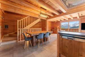 a dining room with a large wooden table and chairs at Les chalets Super Geants in Saint-François-Longchamp
