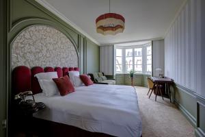 a bedroom with a large bed with a red headboard at Villa Henriette in Cabourg