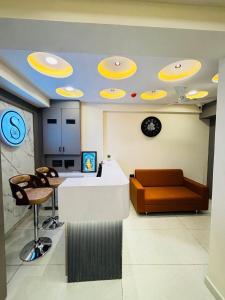 a lobby with a reception desk and a couch at Hotel Sunrise in Ahmedabad
