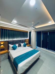 a bedroom with a large bed with blue pillows at Hotel Sunrise in Ahmedabad