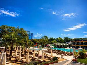 a group of chairs and umbrellas next to a pool at Hotel Palms Beach Kiten in Kiten