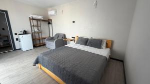 a bedroom with a bed and a chair in it at Hotel Loft Кароліно-Бугаз in Zatoka
