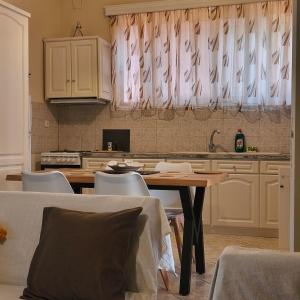 a kitchen with a table with chairs and a sink at Sette Isole Countryside Retreat Near Egremni Beach in Athani