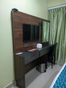 a desk in a room with a television on it at Tourist Inn in Male City