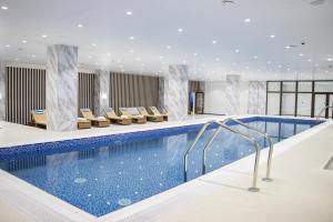 a pool in a hotel with chairs around it at Khubilai Hotel Ulaanbaatar in Ulaanbaatar