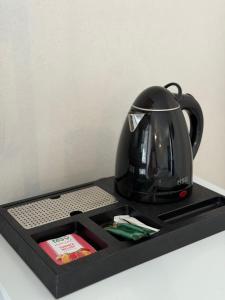 a black tea kettle sitting on a black tray at Hotel Loft Кароліно-Бугаз in Zatoka
