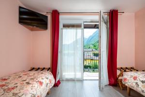a bedroom with a bed and a sliding glass door at B&B La Vecchia Tipografia - Lago D'Idro in Ponte Caffaro