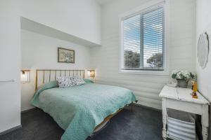 a bedroom with a bed and a window at The Old Guide Hall in Allansford