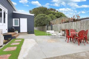 a patio with chairs and a table and a fence at The Old Guide Hall in Allansford
