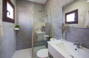 a bathroom with a sink and a toilet and a shower at Casa Poniente, encantadora casa de 2 dormitorios con jardín in Zahora +26 photos
