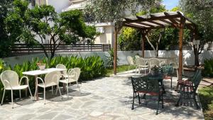 a patio with tables and chairs and a pavilion at Grecian Sea in Limenaria