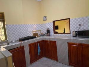 a kitchen counter with a sink and a mirror at Binga villa in Kisoro
