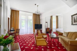 a hotel room with a bed and a living room at Ensana Thermia Palace in Piešťany