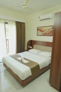 a bedroom with a large bed with towels on it at Ezzora Stays in Kozhikode