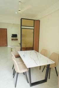 a dining room with a marble table and chairs at Ezzora Stays in Kozhikode