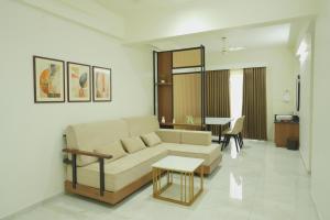 a living room with a couch and a table at Ezzora Stays in Kozhikode +1 photo