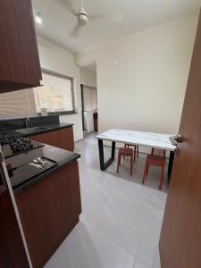 a kitchen with a table and chairs in a room at Ezzora Stays in Kozhikode