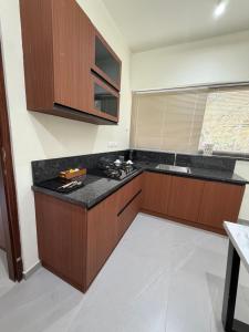 a kitchen with wooden cabinets and a black counter top at Ezzora Stays in Kozhikode