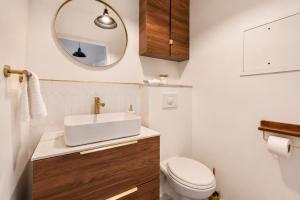 a bathroom with a sink and a toilet and a mirror at Bright & Spacious Apartment near Paris 6 Guests in Clichy