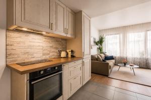 a kitchen with a stove top oven next to a living room at Bright & Spacious Apartment near Paris 6 Guests in Clichy