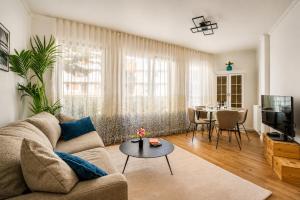 a living room with a couch and a table at Bright & Spacious Apartment near Paris 6 Guests in Clichy