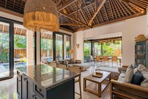an open kitchen and living room with a villa at Kelapa Villas in Gili Trawangan