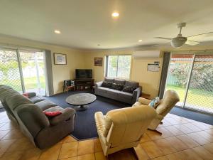a living room with couches and a couch and a table at Wenlaw Cottage Rear Hat Head - Bring your own linen. in Hat Head