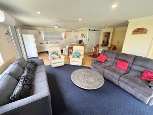 a living room with a couch and a table at Wenlaw Cottage Rear Hat Head - Bring your own linen. in Hat Head
