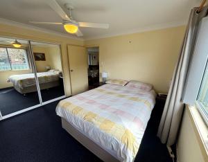 a bedroom with a bed and a mirror at Wenlaw Cottage Rear Hat Head - Bring your own linen. in Hat Head