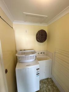a small kitchen with a white refrigerator and a sink at Wenlaw Cottage Rear Hat Head - Bring your own linen. in Hat Head +9 photos