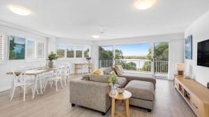 a living room with a couch and a table at The Entrance Unit 5 in Kawana Waters