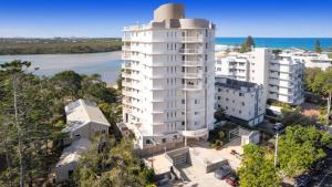 an aerial view of a white building with the ocean at The Entrance Unit 5 in Kawana Waters