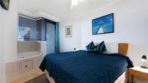 a bedroom with a bed and a bath tub at Grand Pacific Unit 19 in Caloundra +5 photos