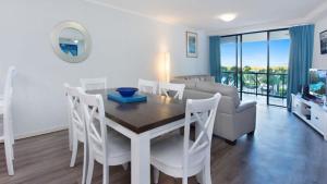 a dining room and living room with a table and chairs at Grand Pacific Unit 19 in Caloundra