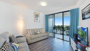 a living room with a couch and a flat screen tv at Grand Pacific Unit 19 in Caloundra