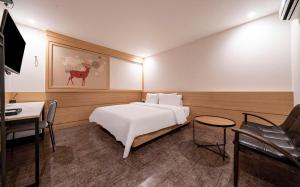 a bedroom with a bed and a table and a desk at 부산 연산동 MU Plus 호텔 in Kŏje